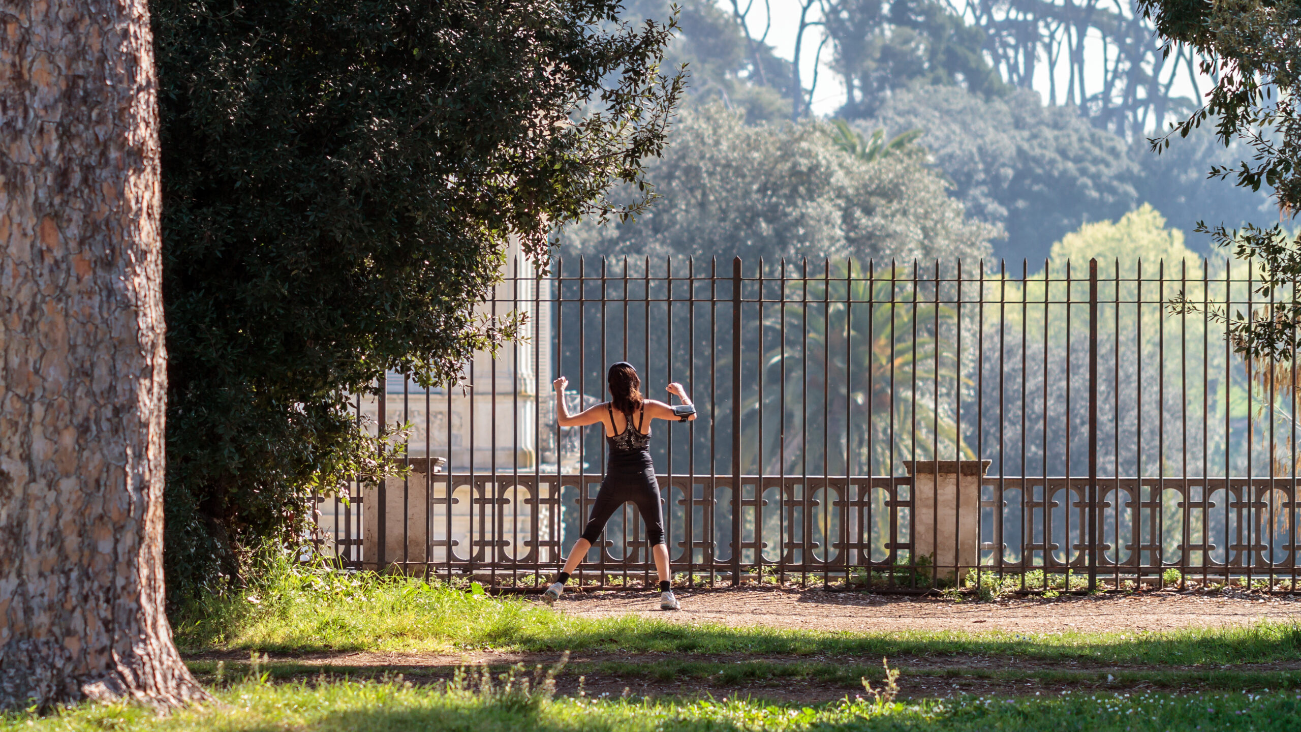 ROME, ITALY - MARCH 29 2014: Young adult woman doing stretching in the City Park of Rome on a warm spring morning on MARCH 29 2014 in Rome in Italy